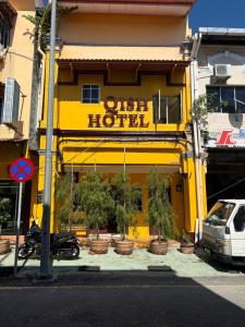 マラッカにあるQish Hotel Melakaの「古いホテル」と書かれた看板のある黄色いホテル