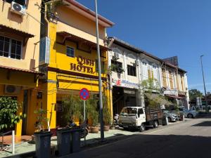 a yellow building on the side of a street at Qish Hotel Melaka in Malacca