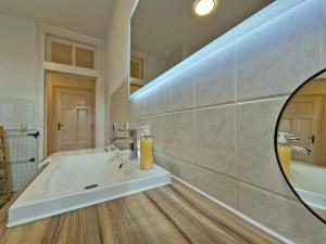 a bathroom with a large tub and a mirror at HappySide Stil & See I 3 Personen I Familienfreundlich I WLAN I Smart TV I PS4 in Markkleeberg