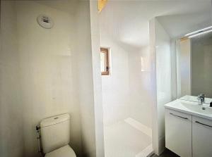 a white bathroom with a toilet and a sink at AO Duplex 82 m2 in Vars +18 photos
