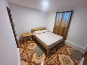 Un dormitorio pequeño con una cama y una ventana. en RB Guesthouse, en San Vicente