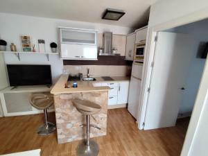 a small kitchen with a counter and two stools at El Refugio 2 Pax - WIFI in Tarifa