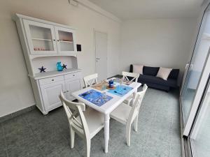 a living room with a table and chairs and a couch at SolMarina Holiday House in Marina di Ragusa