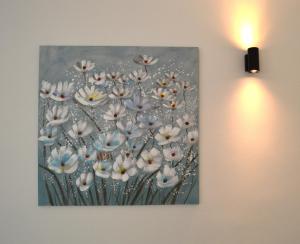 a painting of white flowers hanging on a wall at La Casetta di via Tasso in Piombino