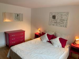 a bedroom with a bed with two night stands and a red dresser at T2 en rez-de-jardin en plein coeur de la Londe les Maures in La Londe-les-Maures