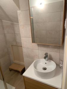 a bathroom with a white sink and a mirror at T2 en rez-de-jardin en plein coeur de la Londe les Maures in La Londe-les-Maures +4 photos