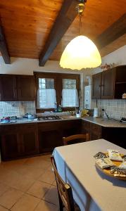 a kitchen with wooden cabinets and a table and a light at Baita "il Fieniletto" in Bannio +10 photos