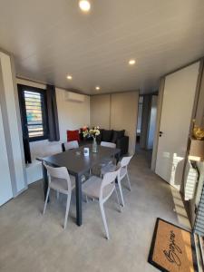 een eetkamer met een tafel, stoelen en een bank bij Cottage Cap d Agde in Agde