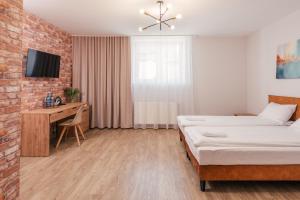 a bedroom with a bed and a desk and a tv at Aparts & Hotel Garbarska in Radom