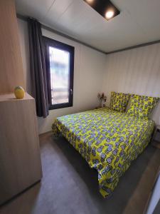 een slaapkamer met een bed met een geel dekbed en een raam bij Cottage Cap d Agde in Agde +15 foto's