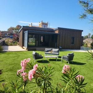 een huis met een bank en stoelen in een tuin bij Cottage Cap d Agde in Agde