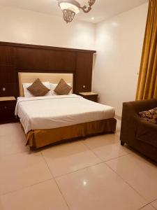 a bedroom with a large bed and a chair at فندق ظلال جدة in Jeddah +4 photos