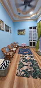 a room with chairs and a rug and blue walls at Homestay Firmasari Jepak in Bintulu +1 photo