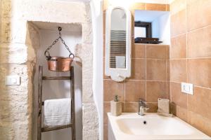 łazienka z umywalką i lustrem w obiekcie Casa Gioia Ostuni w mieście Ostuni