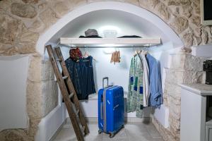 garderoba z niebieską walizką w kamiennej ścianie w obiekcie Casa Gioia Ostuni w mieście Ostuni