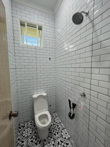 a bathroom with a toilet and a window at Khayla Homestay Kuala Selangor in Kuala Selangor +8 photos