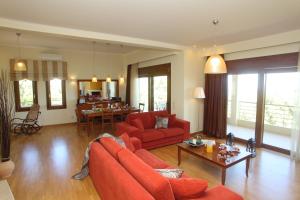 a living room with red furniture and a dining room at Villa Adelais in Tsoukaladhes