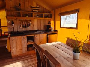 a kitchen with a wooden table and a sink at Glampingtent 6 persoons Lindershoeve Bergeijk in Bergeijk