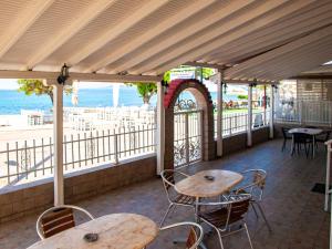 a patio with two tables and chairs and the ocean at Dina Apartments in Fanari