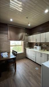 a kitchen with a wooden table and a dining room at شقق البحر الأزرق المخدومه in Nimrān