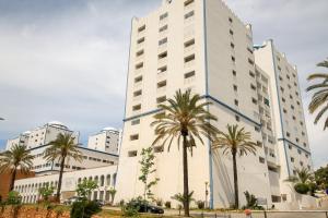 un grand bâtiment blanc avec des palmiers devant dans l'établissement Praia da Rocha Wi-Fi 472, à Praia da Rocha