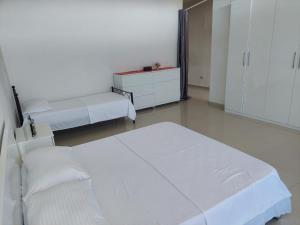 a white room with two beds and a dresser at House Ura e Mesit in Boks