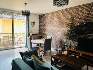 a living room with a christmas tree on a brick wall at Chez Simone in Valréas