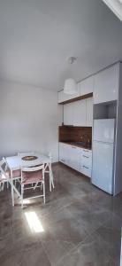 una cucina bianca con tavolo bianco e frigorifero bianco di Dimis Home a Nea Plagia