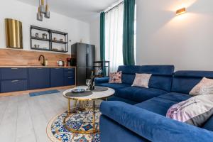 a living room with a blue couch and a table at Apartament Ostróda in Ostróda