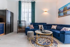 a living room with a blue couch and a table at Apartament Ostróda in Ostróda