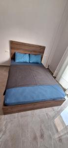 un grande letto con cuscini blu in una stanza di Dimis Home a Nea Plagia