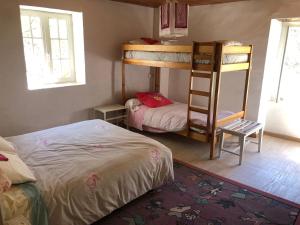 ein Schlafzimmer mit zwei Etagenbetten und einem Bett in der Unterkunft Maison de campagne Les loirs in Lespinassière