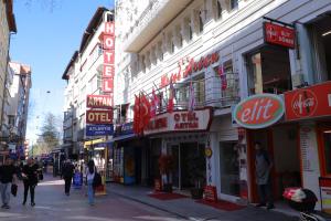 Eine Stadtstraße mit Menschen, die vor Geschäften entlanggehen. in der Unterkunft Artan Hotel in Isparta