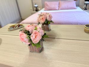 due vasi pieni di fiori rosa su un tavolo di Delux Apartment Argisht Golden Sands a Golden Sands Altre 37 foto