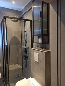 a shower with a glass door in a bathroom at Sodi Cozy apartment in Kardítsa +94 photos