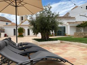 a group of chairs and an umbrella on a patio at Alquería de Tajarja in Tajarja