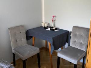 a dining room table with two chairs and a blue table cloth at Willa Plater in Ciechocinek