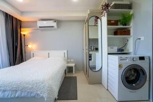 a bedroom with a bed and a washing machine at The Urban Tropical Apartments in Mai Khao Beach