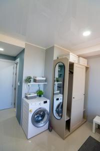 a laundry room with a washing machine and a washer at The Urban Tropical Apartments in Mai Khao Beach