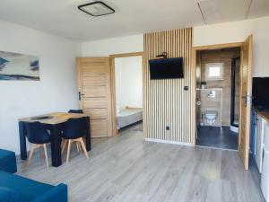 a room with a table and chairs and a bedroom at Morska Fala in Sarbinowo