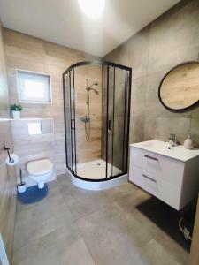 a bathroom with a shower and a toilet and a sink at Morska Fala in Sarbinowo +32 photos
