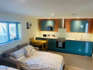 a living room with a couch and a kitchen at The Apartment at Estuary Escapes in Kingsbridge