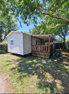 加斯泰Mobil-home Camping Siblu La Reserve ****的院子中带门廊的小白色棚子