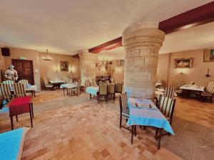a restaurant with tables and chairs and a stone fireplace at L'Hostellerie du Château de Bricquebec in Bricquebec