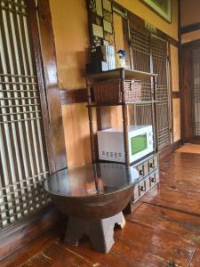 a bath tub in a room with a microwave at Naganeupseong Jandi House in Suncheon