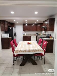 a kitchen with a table with red chairs and a kitchen with a refrigerator at 1 bedroom In a quiet neighborhood near the Main Street- Room A in Rowland Heights