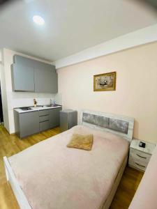 a bedroom with a large bed and a kitchen at Salome in Itʼkhvisi