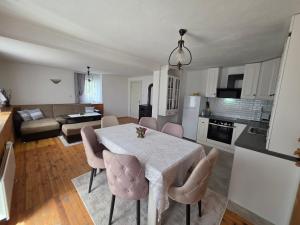 a kitchen and living room with a table and chairs at Къща ВИРА in Yasă-Koriya