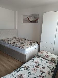 2 Einzelbetten in einem Zimmer mit einem Bild an der Wand in der Unterkunft CoCo Apartment in Ljubljana