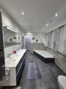 un ampio bagno con due lavandini e una vasca di Moderne hochwertige Wohnung a Rheine